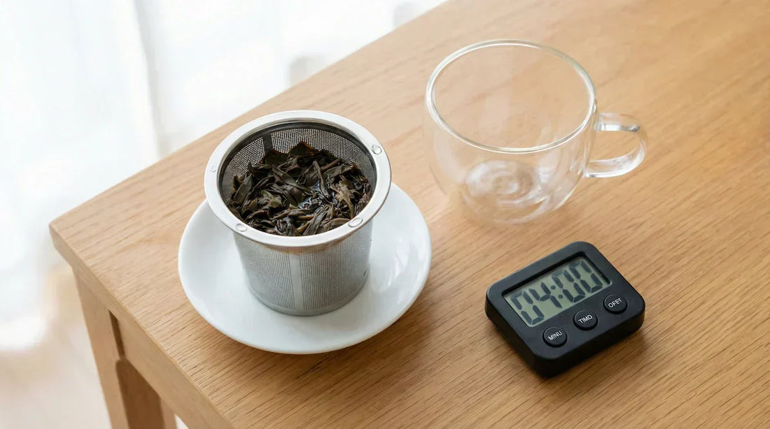 A bright instructional photo showing a tea infuser with wet leaves next to an empty cup and a timer set for 4 minutes, illustrating the setup for re-steeping tea for a second cup.